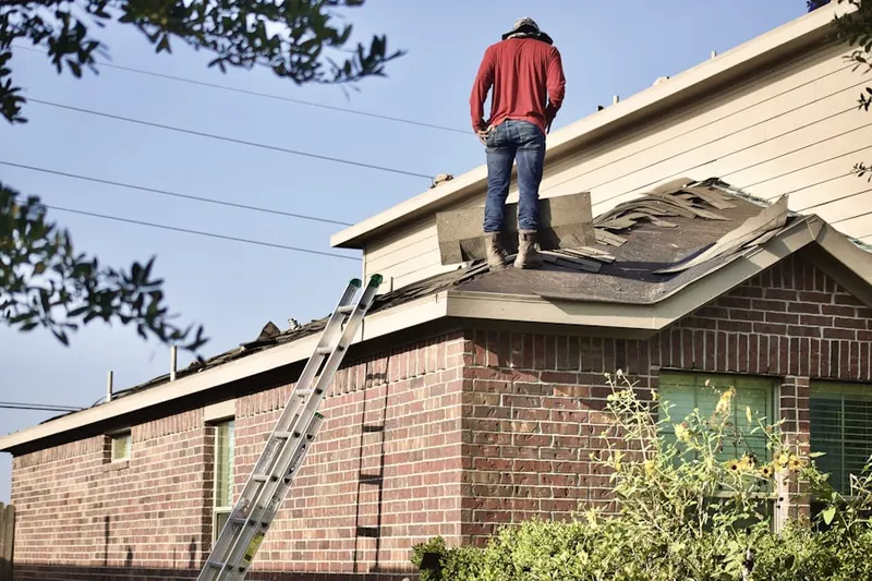 Professional roofer working on a residential roof in Lakeshore at University Park